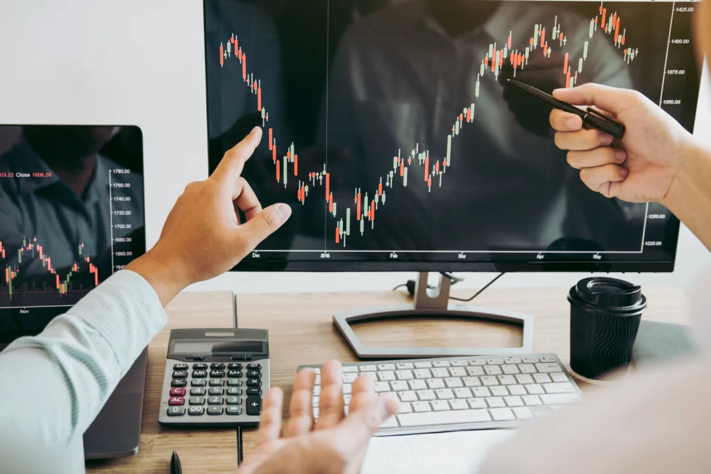 swing traders pointing at trading charts discussing trading strategies