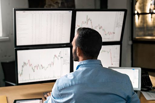 man sitting infront of forex trading screen